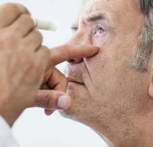 doctor looking at patient eye with light